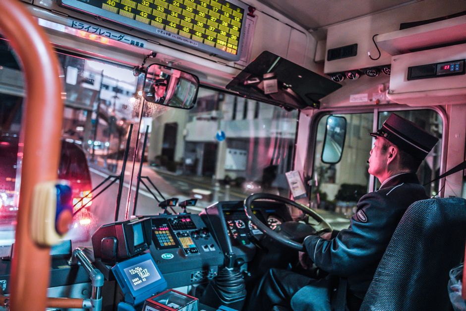 Een buschauffeur van Hermes in een moderne bus, klaar om passagiers te vervoeren.